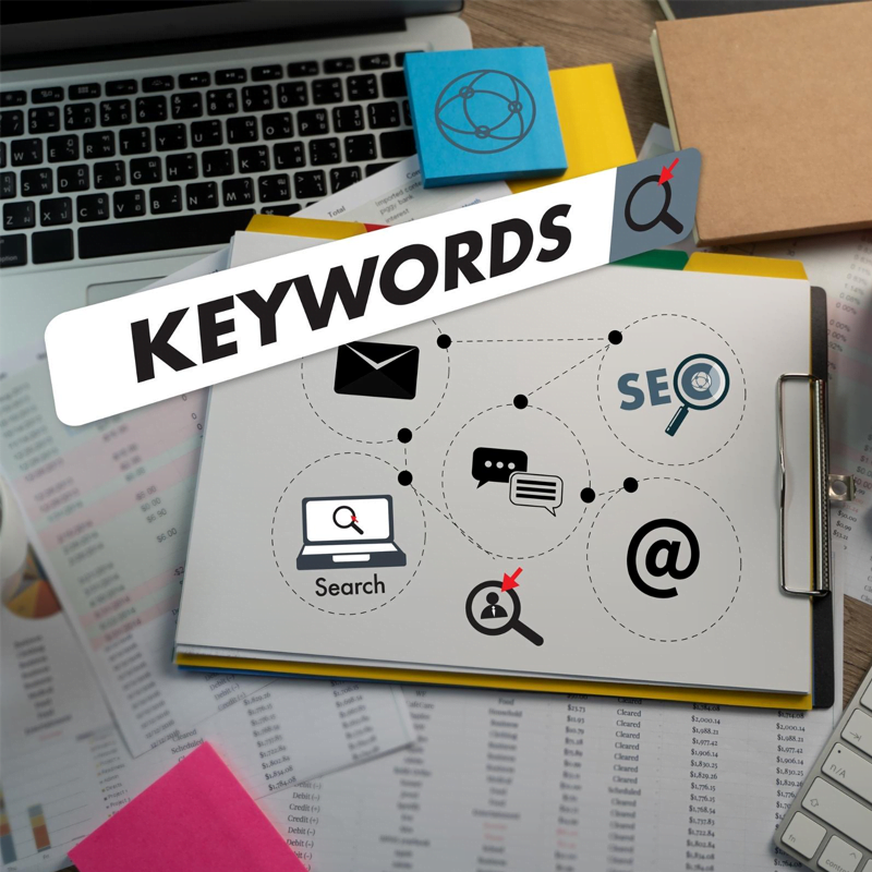 A sketches notebook near laptop with SEO keyword research on different platform.